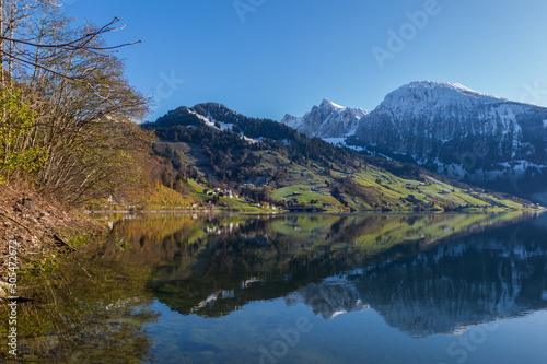 Fototapeta Naklejka Na Ścianę i Meble -  snowcapped mountains reflected in lake Waeggitalersee and blue sky