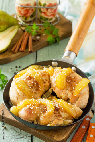 Thanksgiving menu. Baked turkey fillet with caramelized pears in a pan on the kitchen table.