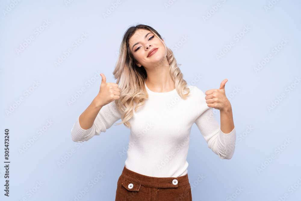 Young teenager girl over isolated blue background with thumbs up gesture and smiling Young teenager girl over isolated blue background with thumbs up gesture and smiling