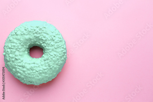 Tasty turquoise donut on color background