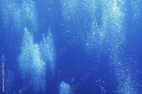Background. The flow of air bubbles rises in the thickness of the water.