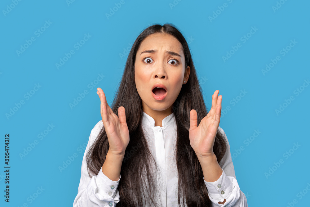 Freestyle. Young woman wearing shirt and skirt standing isolated on blue hands up screaming concerned Freestyle. Young woman wearing shirt and skirt standing isolated on blue hands up screaming concerned