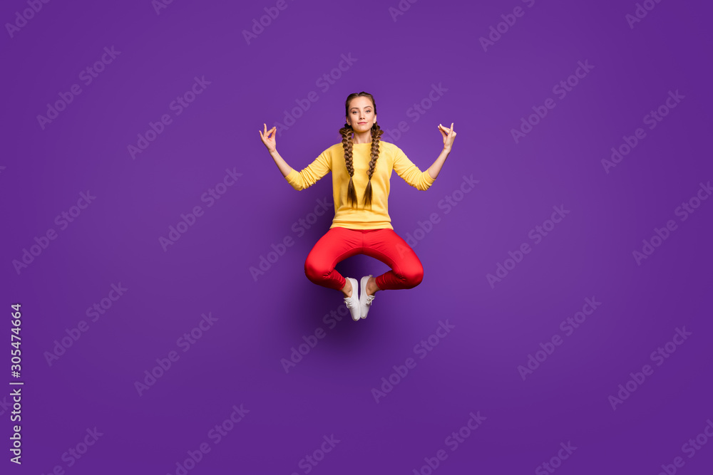Full body photo of crazy youngster lady jumping high in lotus position relaxing yoga training wear casual yellow pullover red trousers isolated purple color background