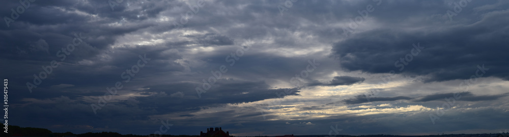 Panoramic photo of the sky. Late summer evening, dense cumulus clouds, pre-storm condition. 