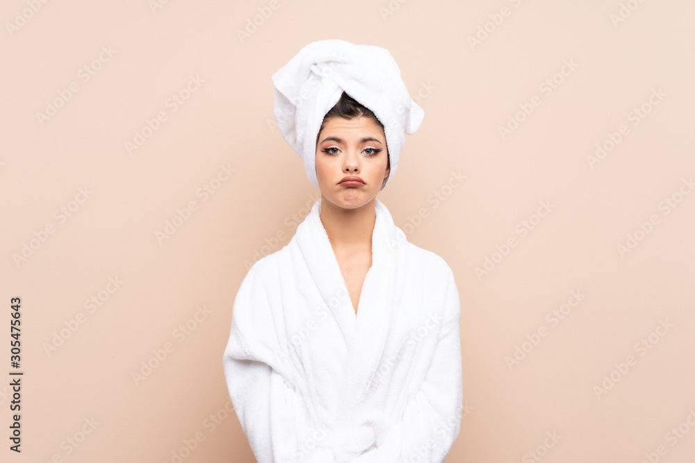 Teenager girl in a bathrobe over isolated background sad Teenager girl in a bathrobe over isolated background sad
