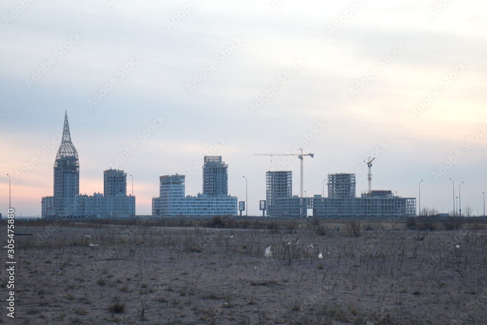 Construction of a residential quarter on the outskirts of the city on an autumn evening