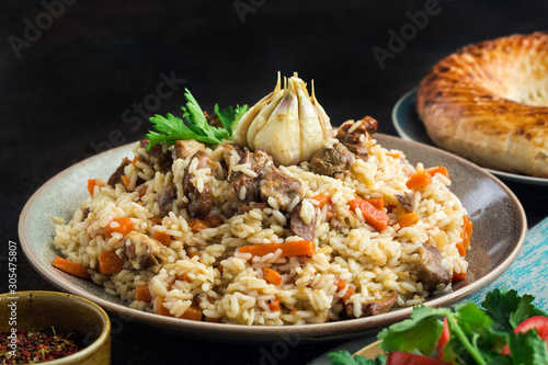 Uzbekistan  national dish - plov, made from: uzbek Devzira rice, lamb, onion, carrot, spiced with cumin, coriander, barberries, red pepper, prepared with head of garlic. photo