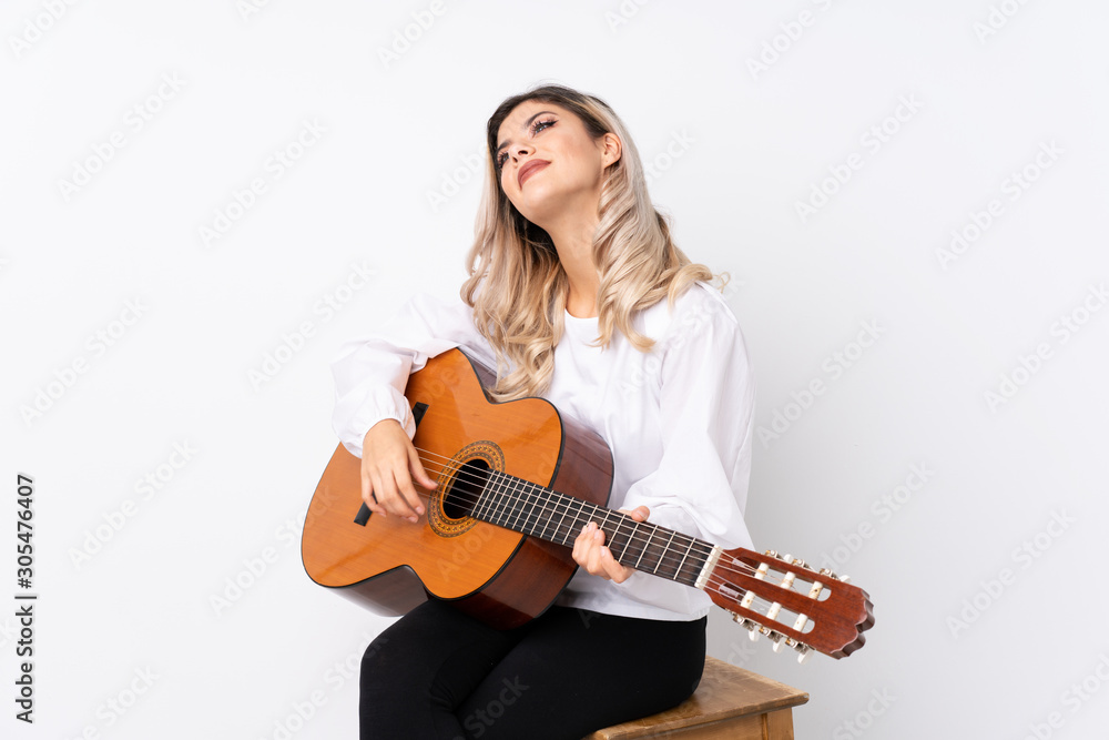 Teenager girl with guitar over isolated white background looking up while smiling Teenager girl with guitar over isolated white background looking up while smiling