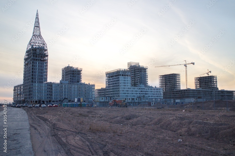 Fototapeta premium Construction of a residential quarter on the outskirts of the city on an autumn evening