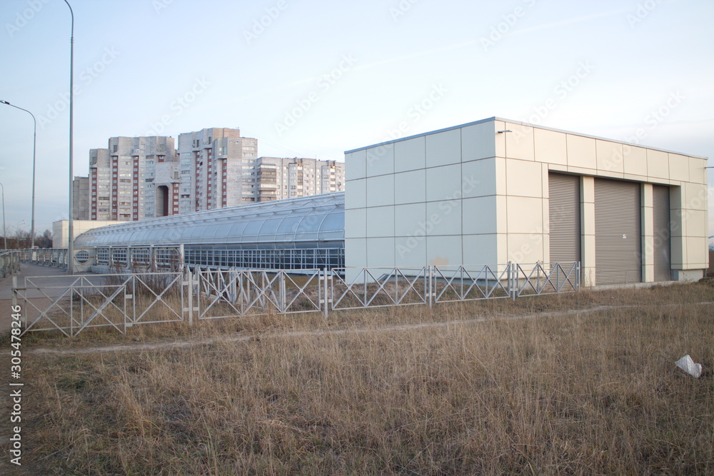 Covered pedestrian bridge on the outskirts of the city in autumn twilight