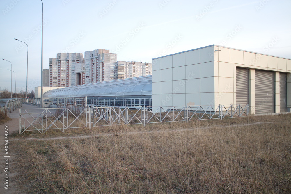 Covered pedestrian bridge on the outskirts of the city in autumn twilight Covered pedestrian bridge on the outskirts of the city in autumn twilight