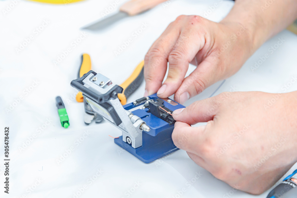 Fototapeta premium Expert technician Using a fiber-optic cable cutter With cutter For accuracy in work