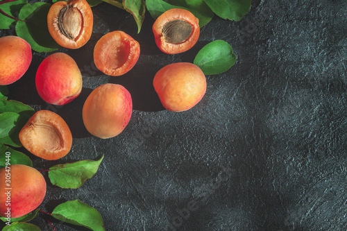 ripe fresh apricots and apricot halves on the table top view. background with apricots and leaves.