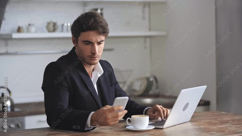 businessman typing, talking on smartphone and drinking coffee businessman typing, talking on smartphone and drinking coffee