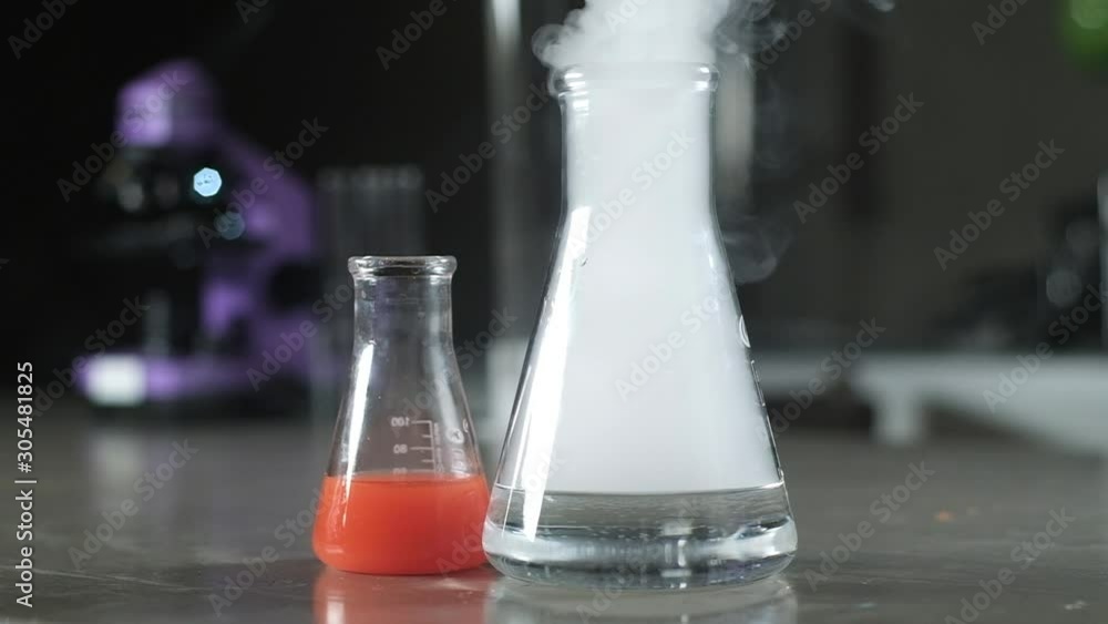 Beakers and test tubes with the solution are in the laboratory. Scientific experiment in biochemistry. chemical modern laboratory. Liquid Nitrogen evaporates from the test tube. Cryogenic freezing. Beakers and test tubes with the solution are in the laboratory. Scientific experiment in biochemistry. chemical modern laboratory. Liquid Nitrogen evaporates from the test tube. Cryogenic freezing.