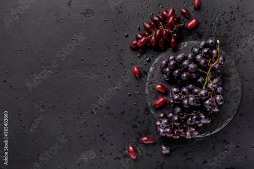 Healthy flat lay of colored grape on black background