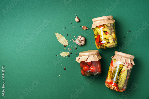 Сucumber, squash and tomatoes pickling and canning into glass jars. Ingredients for vegetables preserving. Healthy fermented food concept. Top view. Copy space.