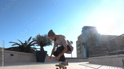 Close up of skater skateboarder man doing 360 kickflip heelflip flip trick in slow motion jump