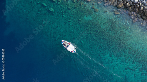 Aerial drone photo of traditional wooden fishing boat in old port of Mykonos island, Cyclades, Greece