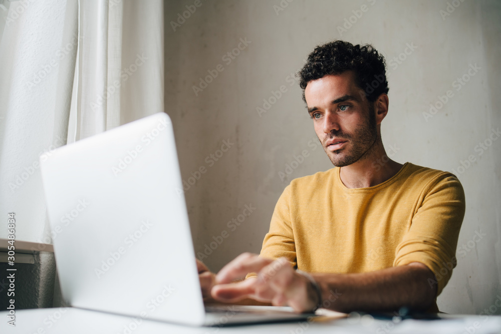 Mid adult man using laptop at home Mid adult man using laptop at home