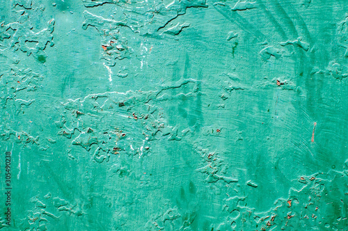 Grunge weathered cracked painted plastered wall closeup as green background