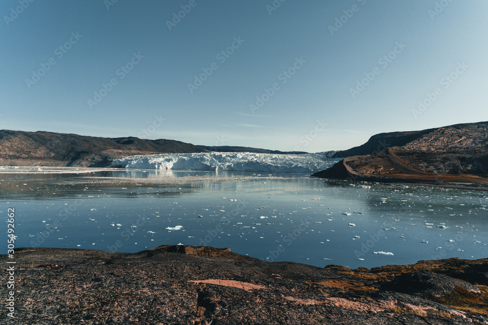 Obraz premium Panoramic image of Camp Eqi at Eqip Sermia Glacier in Greenland. nature landscape with lodge cabins. Midnight sun and pink sky. Tourist destination Eqi glacier in West Greenland AKA Ilulissat and