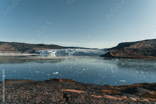 Panoramic image of Camp Eqi at Eqip Sermia Glacier in Greenland. nature landscape with lodge cabins. Midnight sun and pink sky. Tourist destination Eqi glacier in West Greenland AKA Ilulissat and