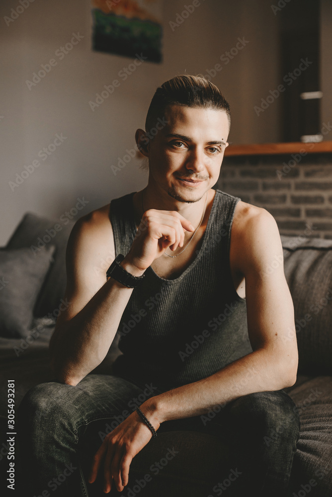 Portrait of a handsome relaxed man sitting on a leather sofa with a glass of wine in a modern stylish living room. Portrait of a handsome relaxed man sitting on a leather sofa with a glass of wine in a modern stylish living room.