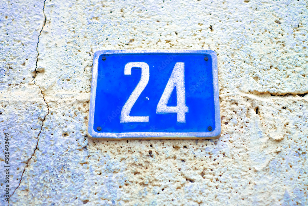 Number 24, twenty-four, blue plate with white digits, cracked wall. Number 24, twenty-four, blue plate with white digits, cracked wall.