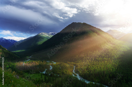 Fototapeta Naklejka Na Ścianę i Meble -  Mountain river valley landscape. A mountain massif in the sunset rays.