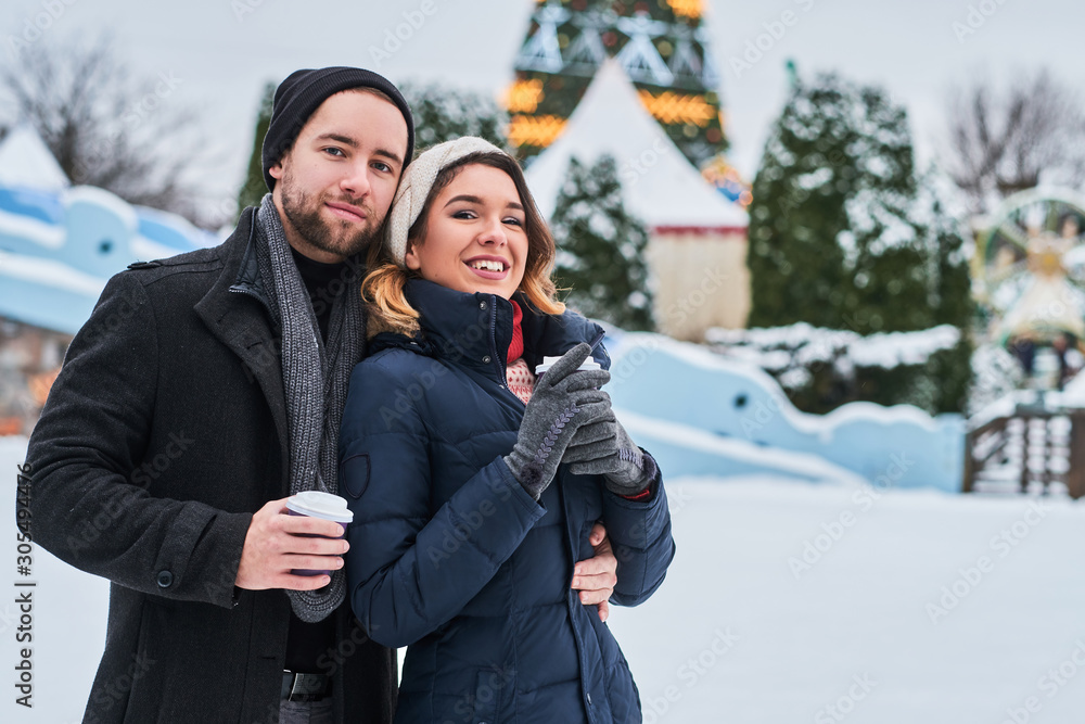 Young couple on a date near the ice rink, drinking coffee and talking Young couple on a date near the ice rink, drinking coffee and talking