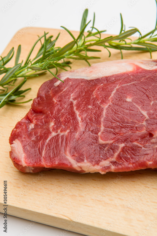 Raw seasoned beef slice on a wooden board Raw seasoned beef slice on a wooden board