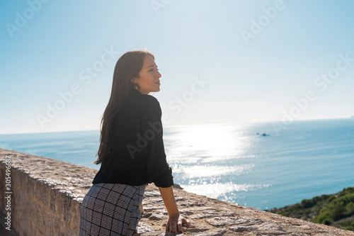 Young brunette woman looking at distance vom viewpoint in Ibiza photo