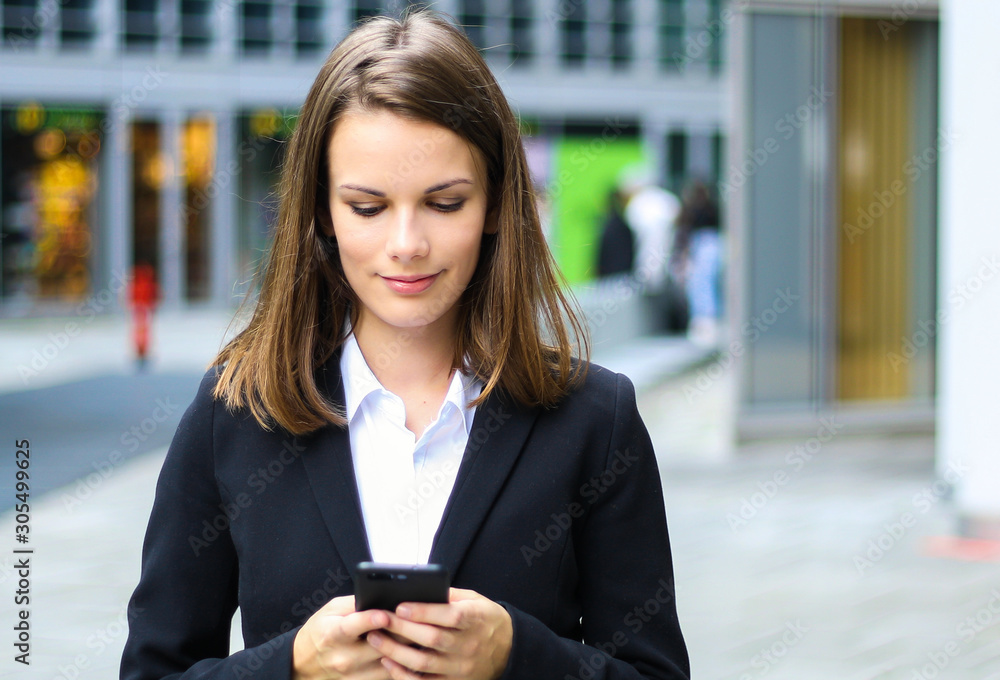 Smiling businesswoman using a smartphone outdoor Smiling businesswoman using a smartphone outdoor