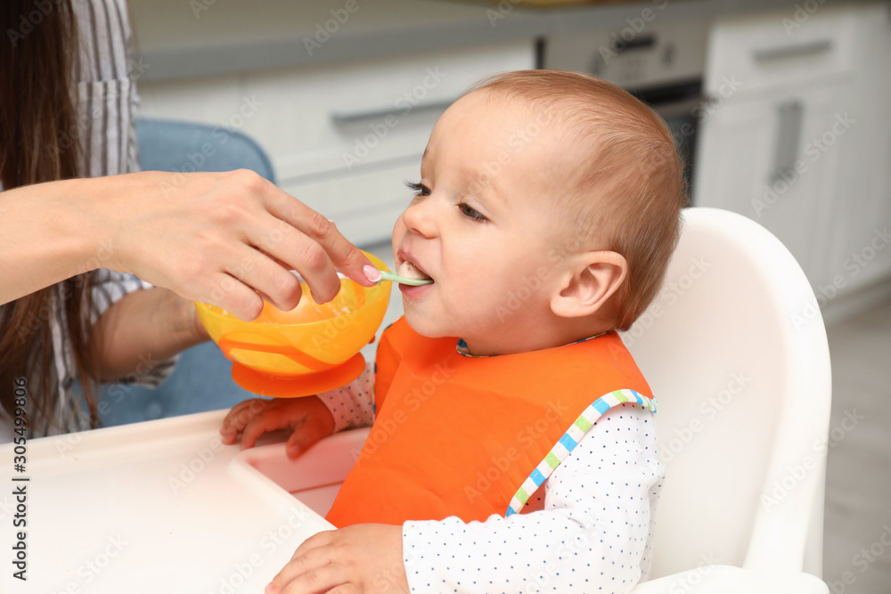 Young mother feeding her little baby at home Young mother feeding her little baby at home