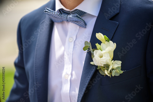 groom in a jacket, boutonniere on a jacket, the groom adjusts his jacket, The morning of the groom, business style, man in a jacket