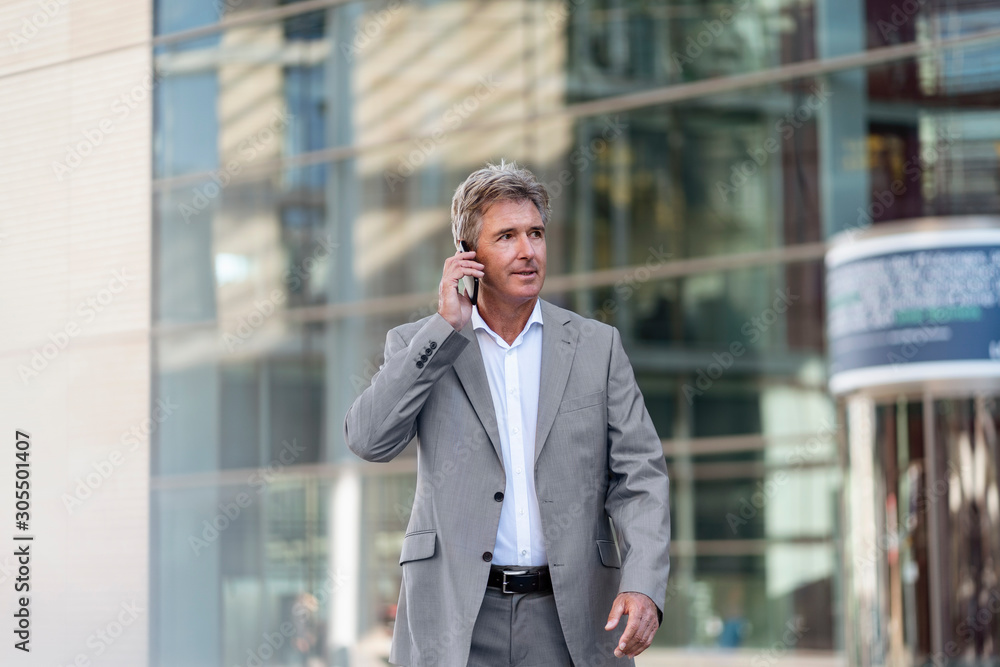 Mature businessman on the phone in the city Mature businessman on the phone in the city