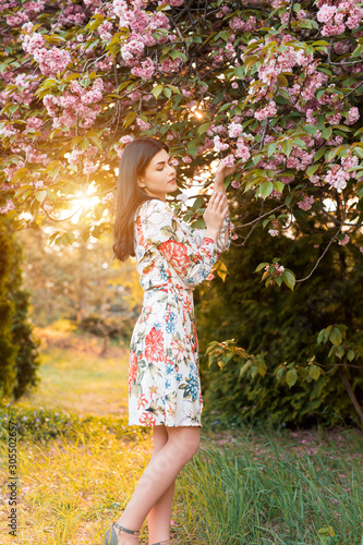 Charming woman in garden under flowering tree