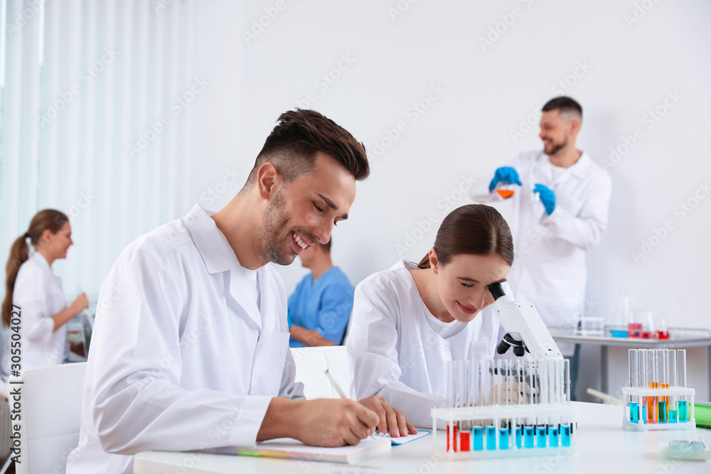 Medical students with microscope in modern laboratory Medical students with microscope in modern laboratory