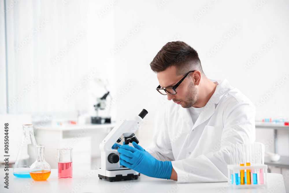 Scientist using modern microscope at table. Medical research Scientist using modern microscope at table. Medical research