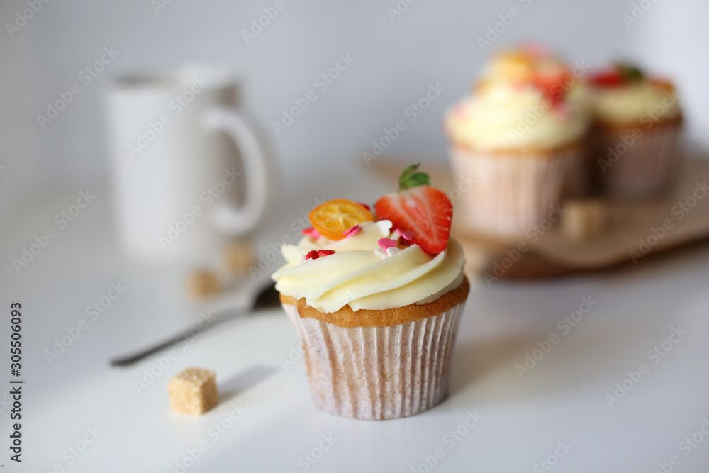 cupcake with cream cheese decorated with strawberries on a white background. cupcake with cream cheese decorated with strawberries on a white background.