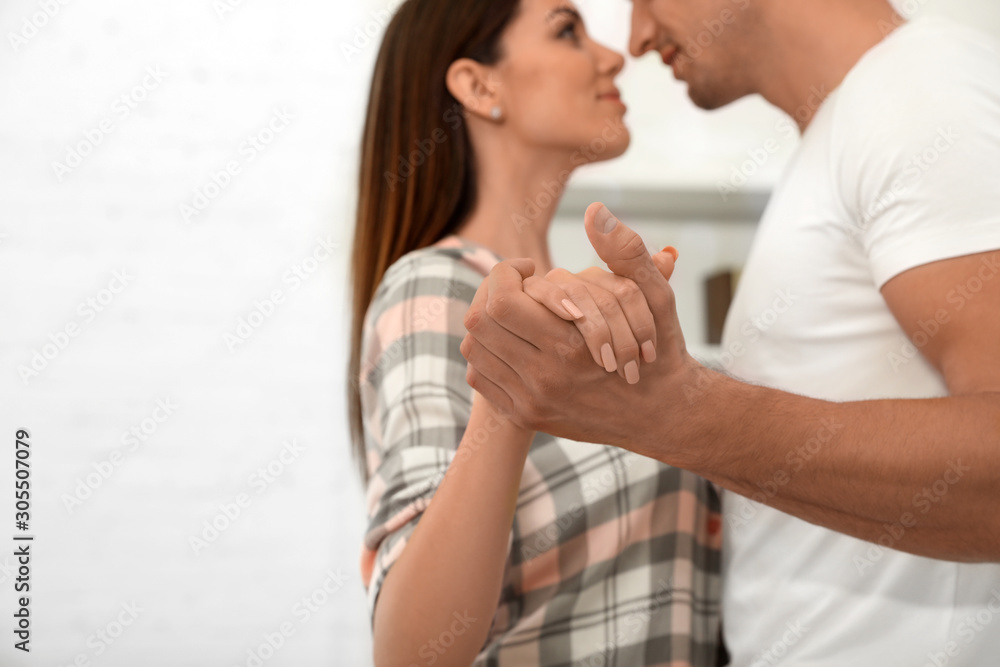 Happy young couple dancing at home, focus on hands Happy young couple dancing at home, focus on hands