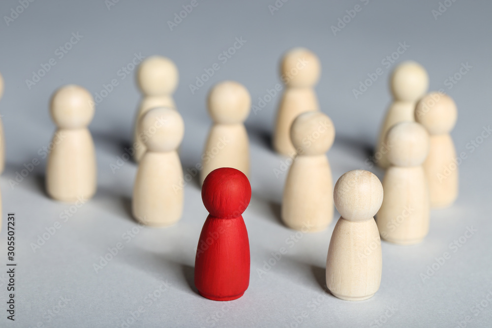 Leader concept. Wooden figures on grey background Leader concept. Wooden figures on grey background