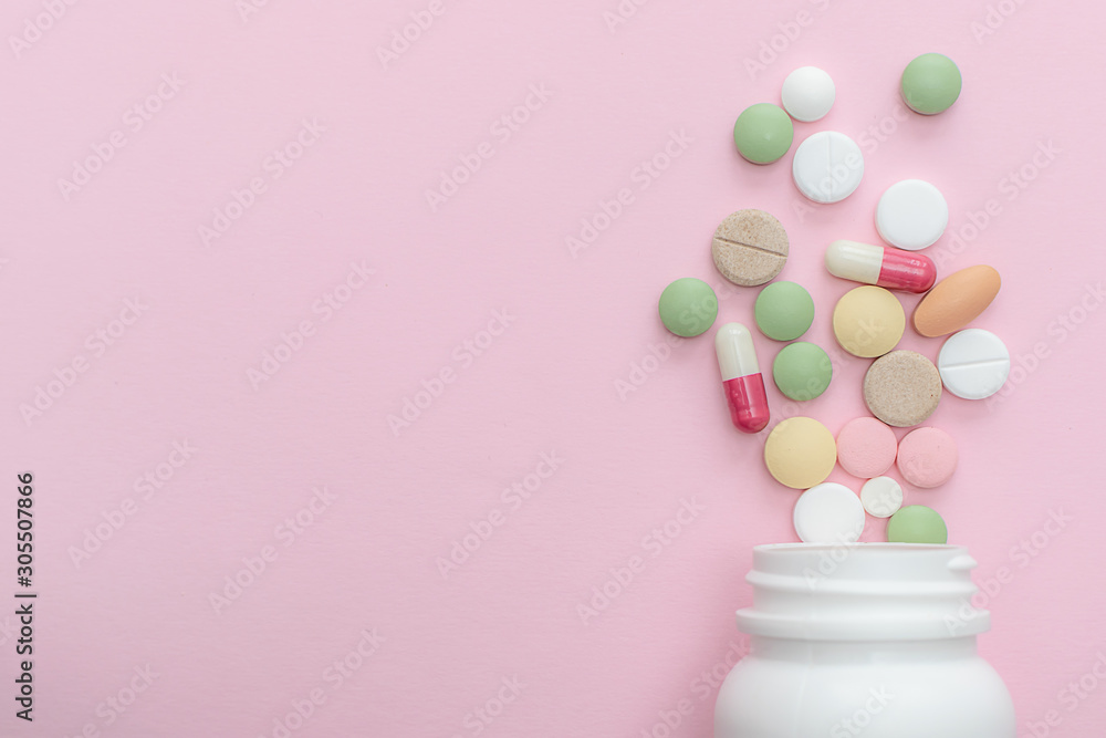 Colorful medical tablets, pills and capsules on pink pastel background with copy space for your design. Health care concept. Colorful medical tablets, pills and capsules on pink pastel background with copy space for your design. Health care concept.