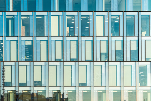 Glass facade texture of a modern office building. High tech architecture. Elements of urban design. Reflections in the windows.