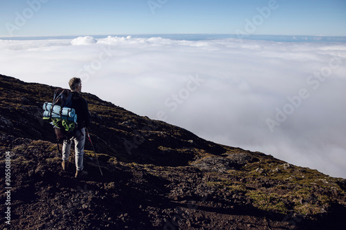 Hiker on viewpoint looking at distance, Ponta do Pico, Azores, Portugal photo