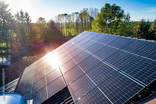 Solar panels and sunlight reflextions on the roof against blue sky background. Concept clean power energy. photo