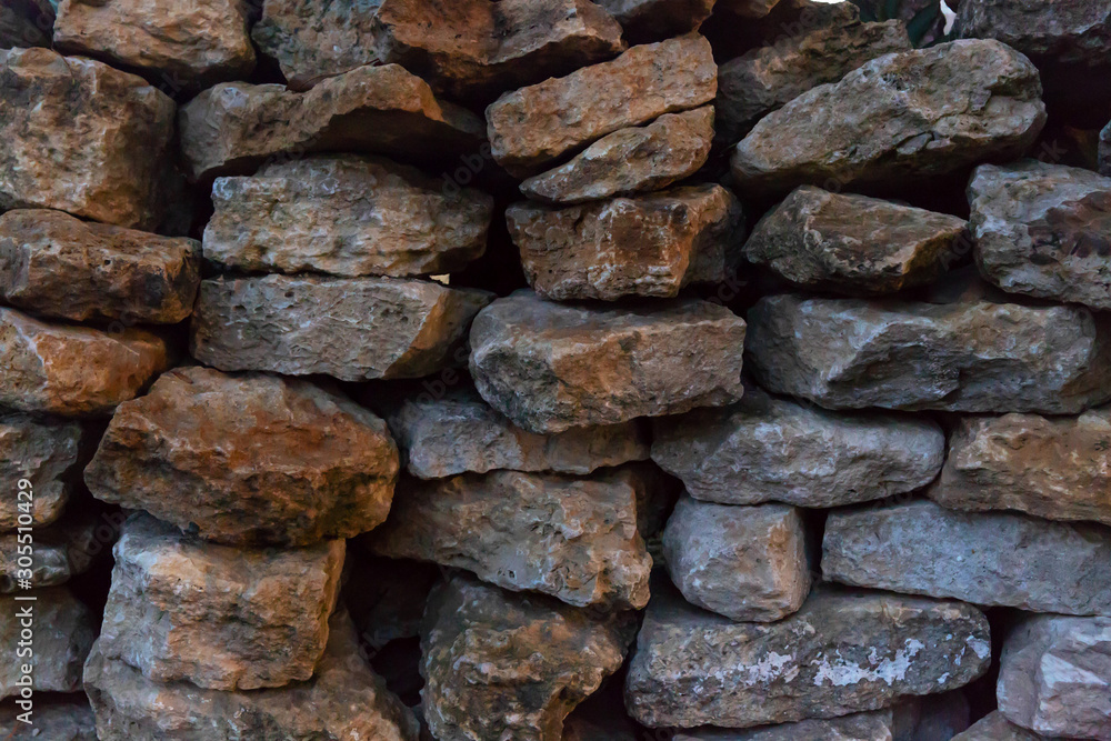 Background image of a stone wall made of natural gray and brown stone on dry. Background image of a stone wall made of natural gray and brown stone on dry.