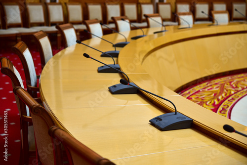 Round table with microphones for diplomatic negotiations in the hall