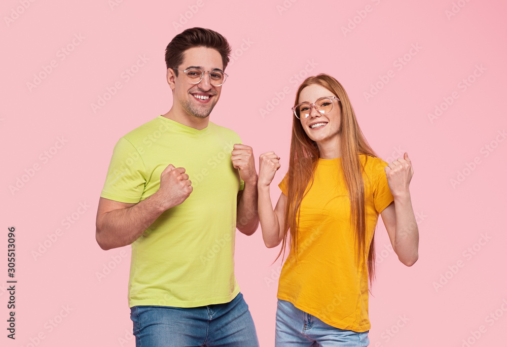 Cheerful young couple celebrating success Cheerful young couple celebrating success